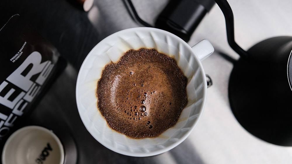 Freshly roasted coffee blooming in a V60 pour-over dripper