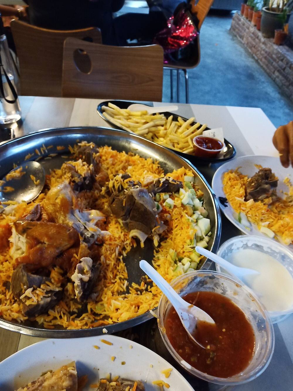 Plates of chicken and lamb mandi rice served with french fries