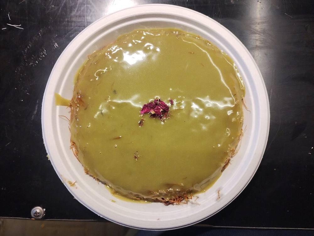 A pistachio kunafa dessert, a golden shredded pastry topped with crushed pistachios
