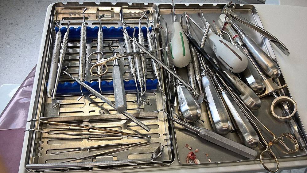 A set of stainless steel dental instruments laid out on a tray
