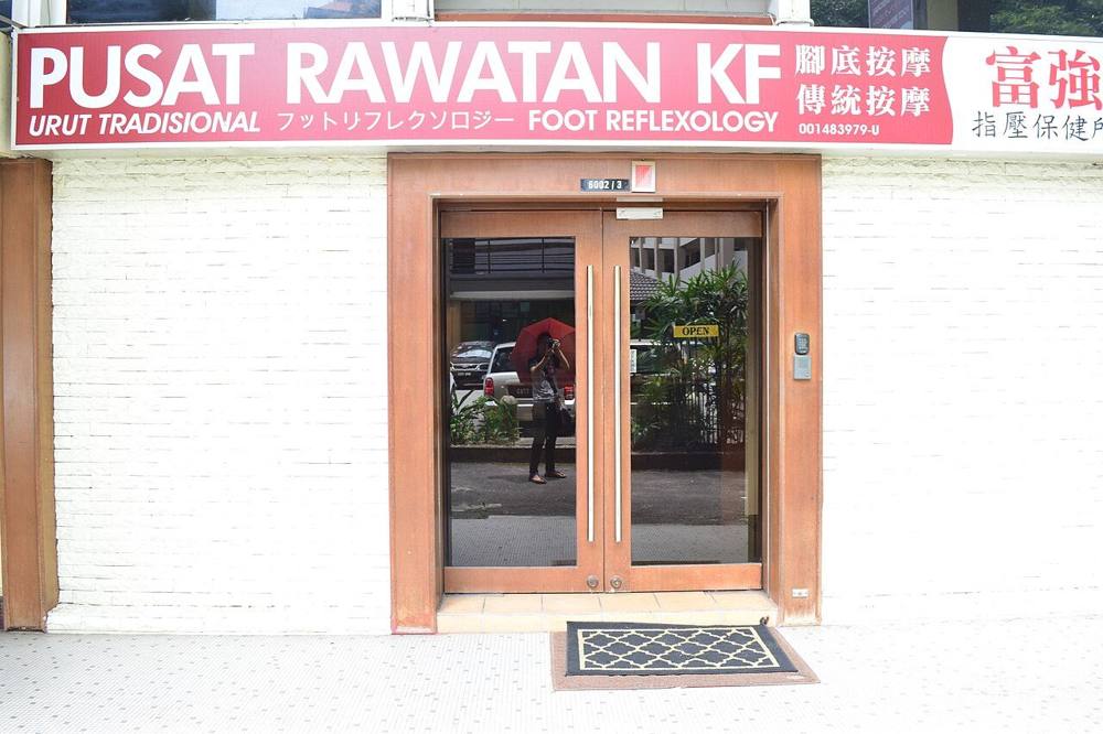 The shopfront of a traditional foot reflexology centre with trilingual Malay, English and Chinese signage