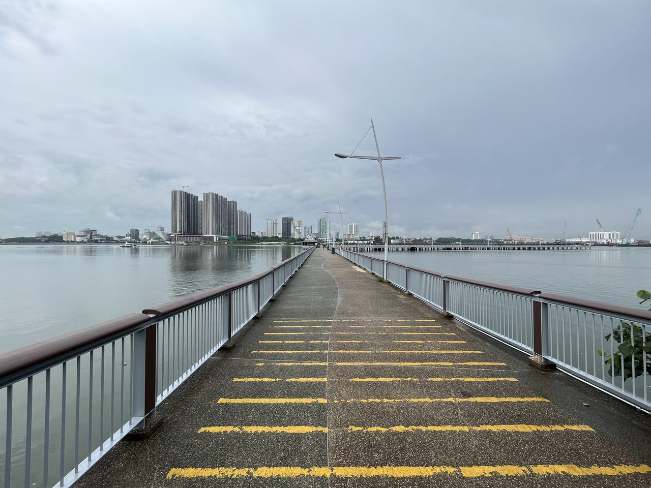 View across the Straits of Johor from Woodlands Waterfront Park jetty toward the Johor Bahru city waterfront
