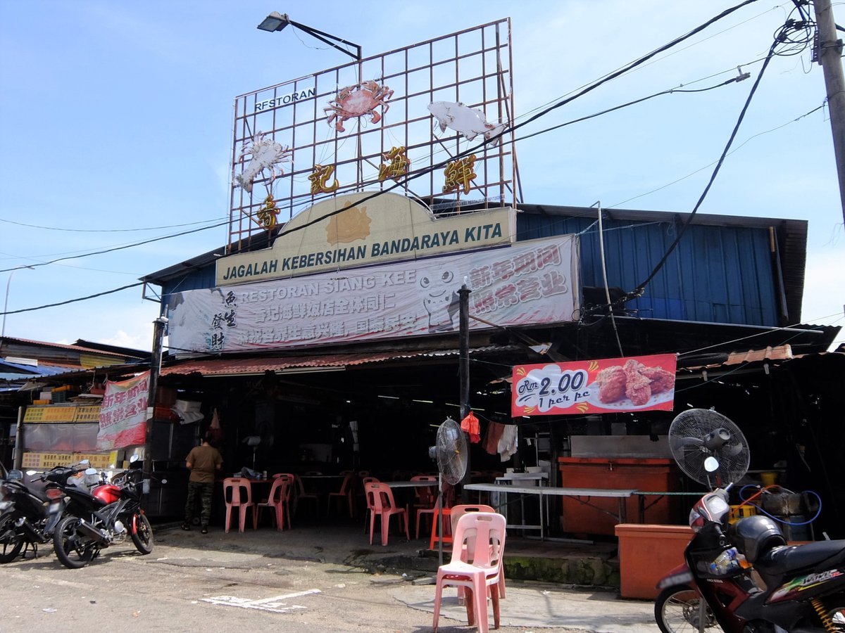 Open-air night food court stalls with crowds and bright lights