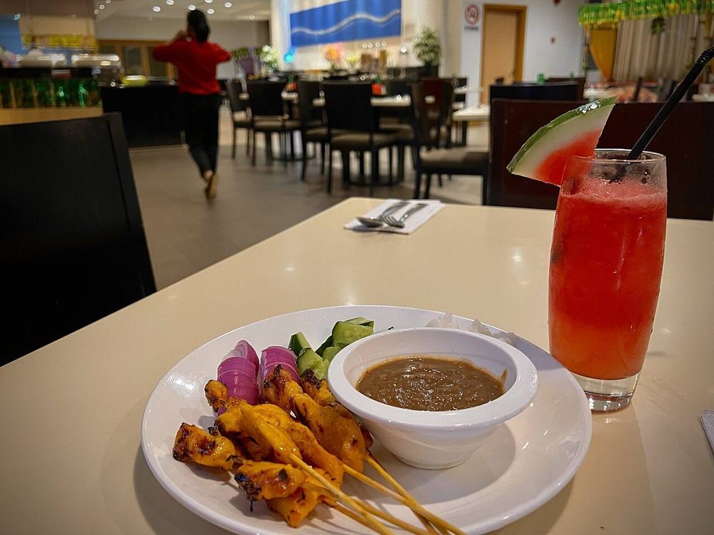 Satay skewers on a plate with dipping sauce