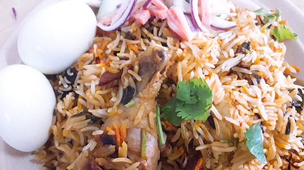 Nasi briyani gam with chicken, boiled egg and cucumber salad