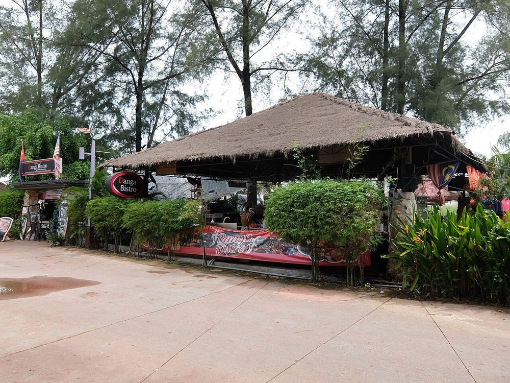An open-air thatched-roof eatery among casuarina trees at Danga Bay