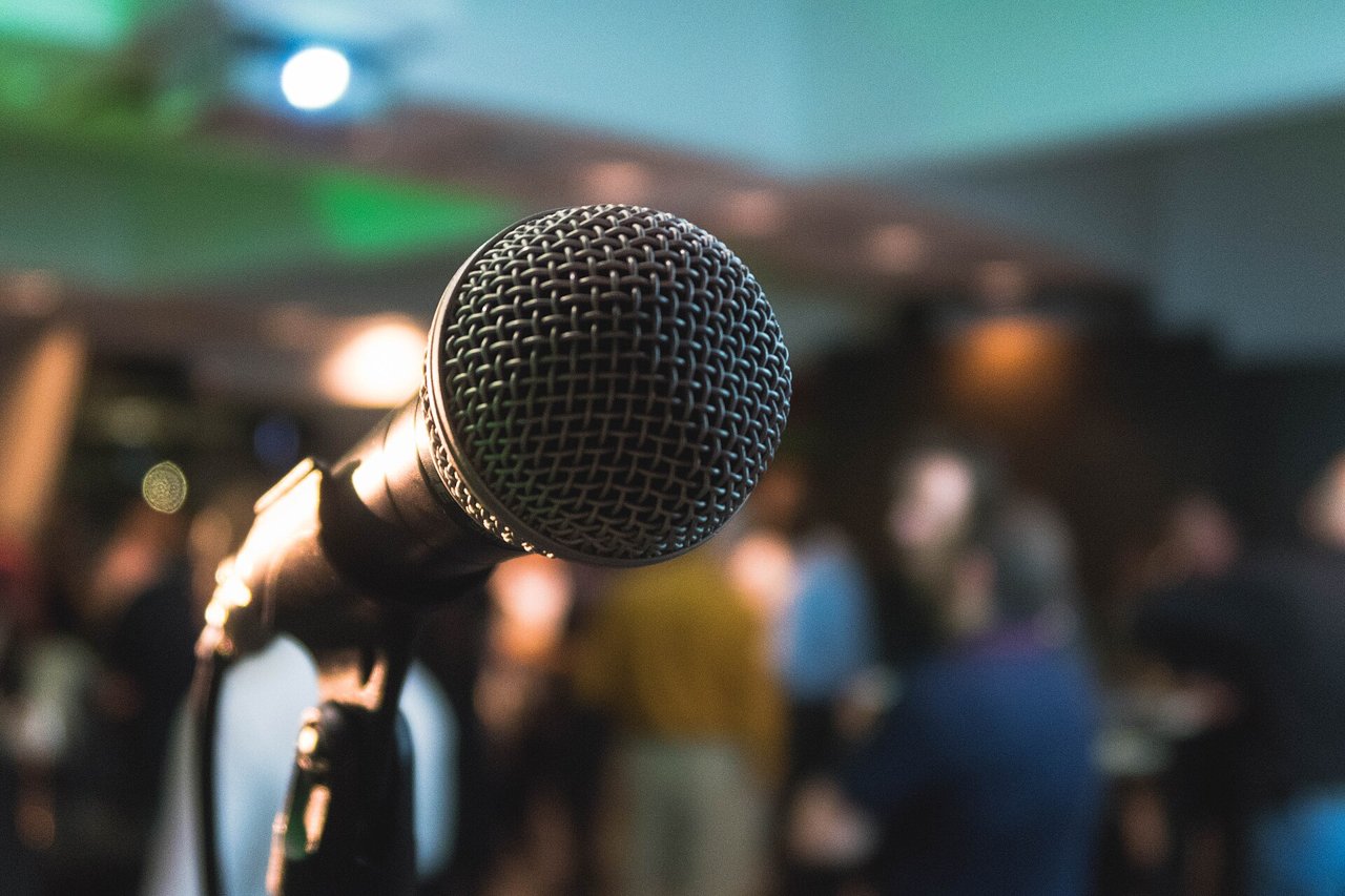 A microphone under warm stage lights on a karaoke night, KTV near KSL