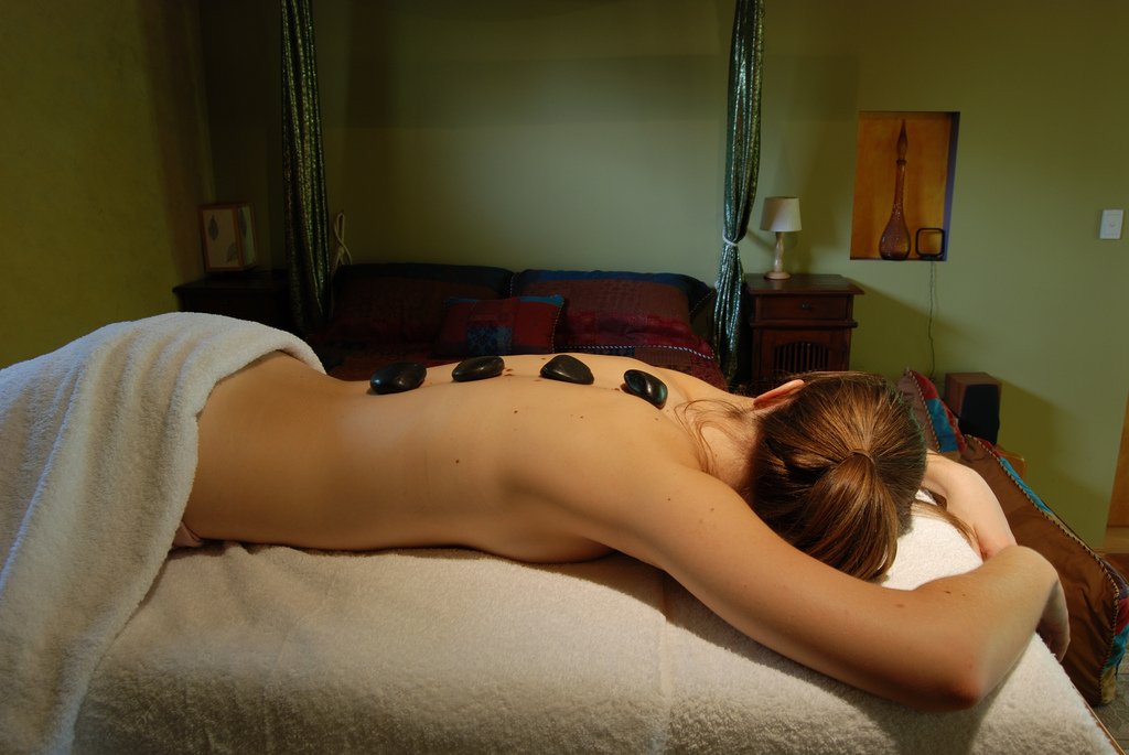 A relaxing hot stone massage at a warmly-lit spa, massage near KSL